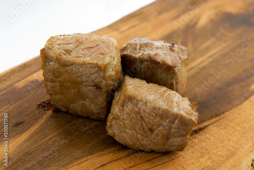 fresh baked meat cubes on a wooden board