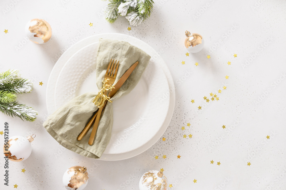 Christmas festive table setting with white plate, golden balls on white background. View from above. Copy space. Xmas dinner. Christmas festive table setting with white plate, golden balls on white background. View from above. Copy space. Xmas dinner.