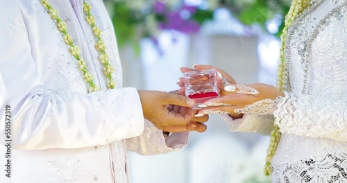 The dowry that the groom gave to the bride. Declaration of love at Indonesian weddings. Close up of loving male holding small box with diamond ring in hand presenting it to beloved young female