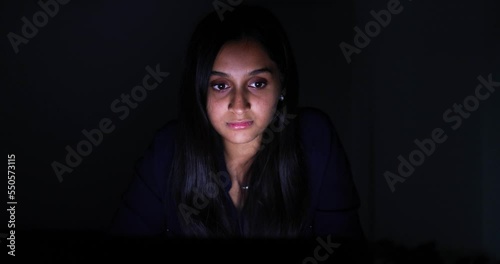 Face of young woman looking at illiminated screen photo