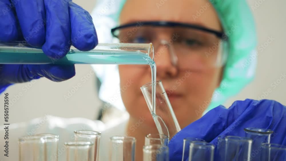 Female scientist working with test tubes in lab.