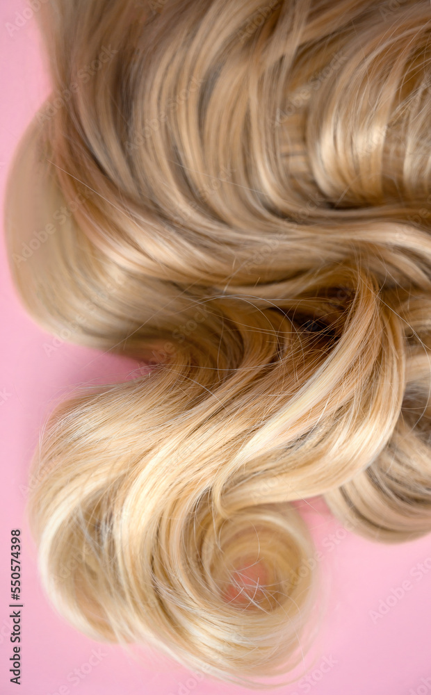 Fototapeta premium texture of beautiful glossy long hair. Twist female healthy hair. Hairdressing spa concept. strand of blond silky hair.