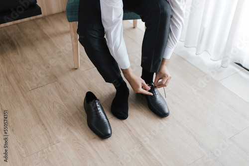 Business man getting ready by tying shoelaces.