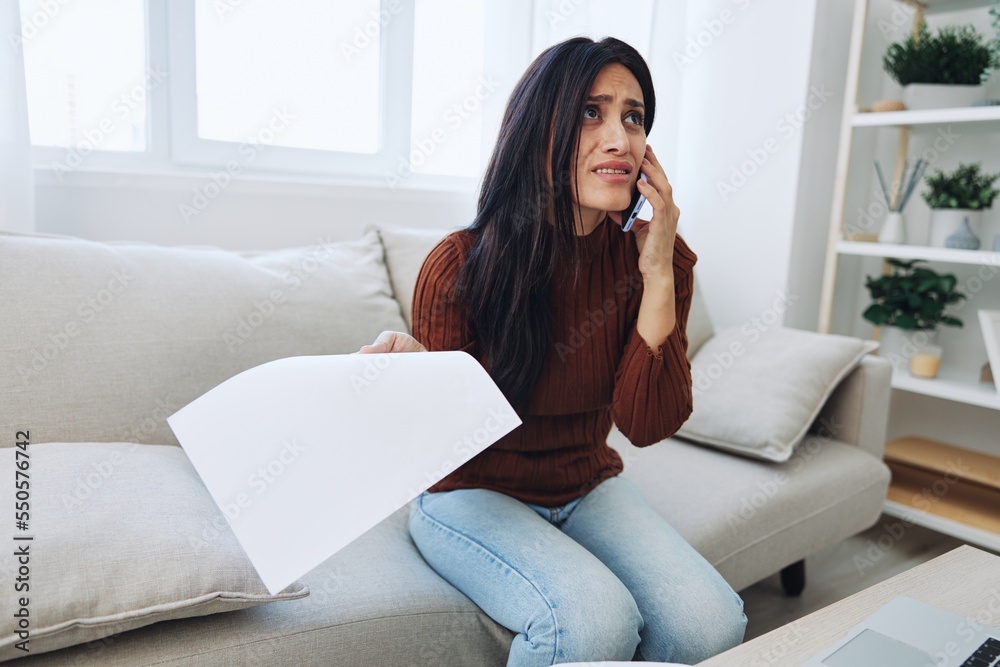 Woman talking on phone angry and sad at home, fight over phone throwing papers, bad news at work and family Woman talking on phone angry and sad at home, fight over phone throwing papers, bad news at work and family