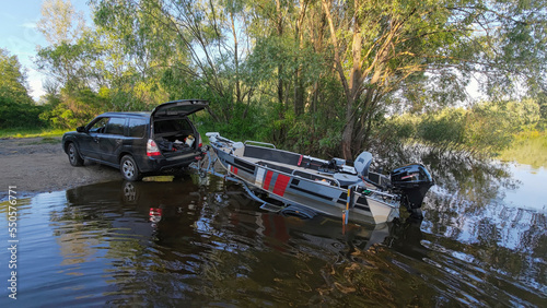 Dumping a boat from a trailer into a wild river. Slip fishing boat before fishing.