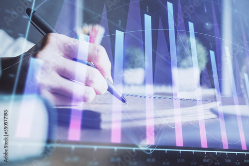 Financial forex charts displayed on woman's hand taking notes background. Concept of research. Double exposure