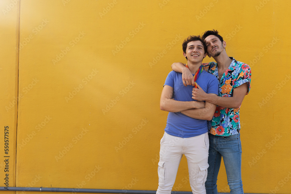 Happy young couple embraces. Two men enjoy outside