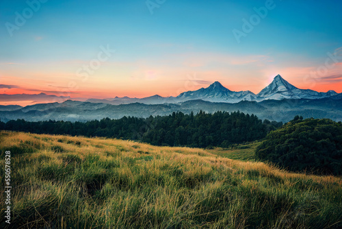 Ethereal mountain sunset views over a calming forest wooldland vista beautiful lighting photo