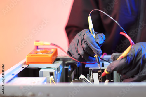 checking the voltage with an ammeter in an old computer on the table photo