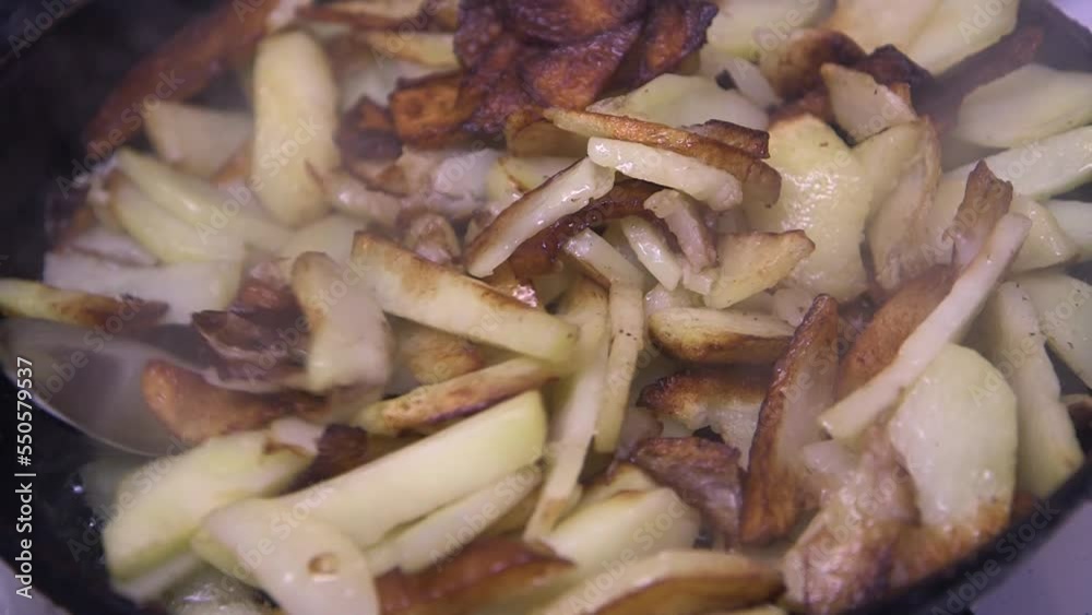 the cook stirs appetizing potatoes in a frying pan, close-up
the cook stirs appetizing potatoes in a frying pan, close-up