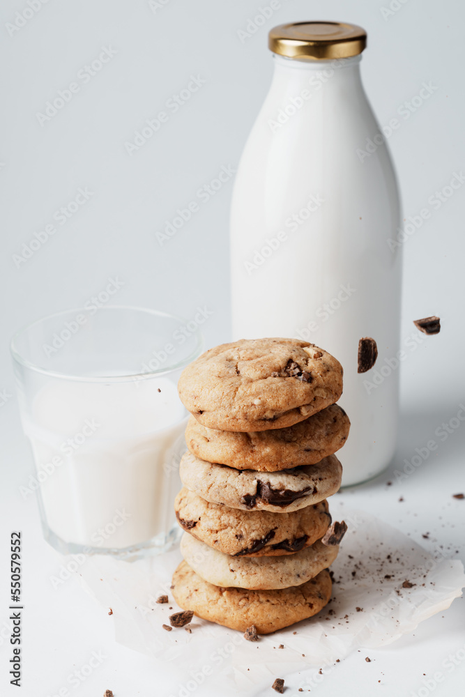 Homemade cookies are sprinkled with chocolate on the background of a bottle of milk and a glass Homemade cookies are sprinkled with chocolate on the background of a bottle of milk and a glass