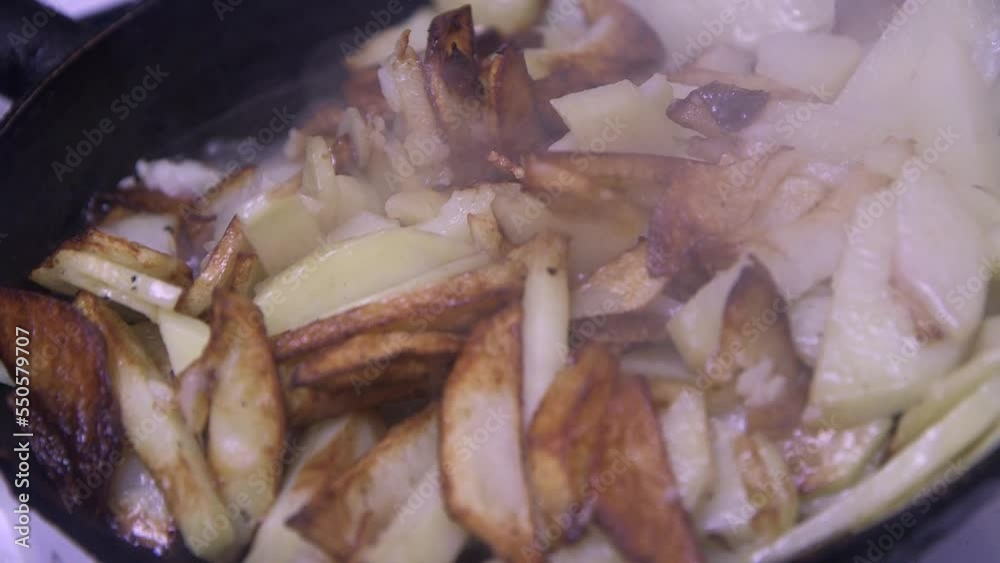 sliced potatoes with a crust fry in a pan, close-up sliced potatoes with a crust fry in a pan, close-up