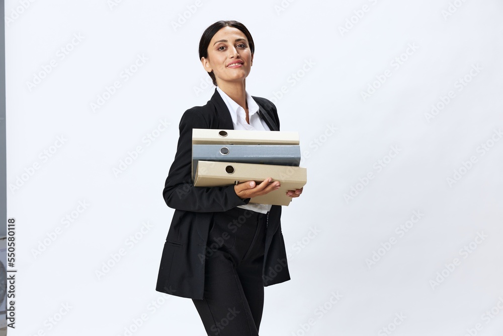Business woman with a folder of documents in her hands in a black business suit and glasses shows signals gestures and emotions on a white background, work freelancer online training