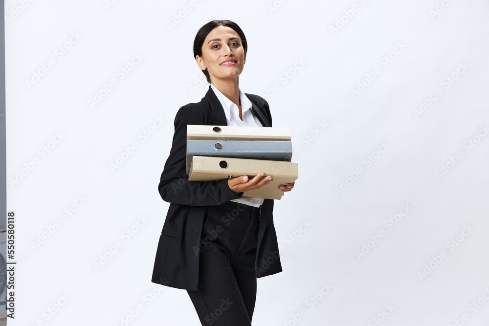 Business woman with a folder of documents in her hands in a black business suit and glasses shows signals gestures and emotions on a white background, work freelancer online training Business woman with a folder of documents in her hands in a black business suit and glasses shows signals gestures and emotions on a white background, work freelancer online training