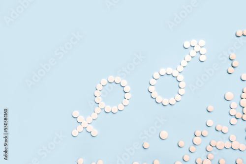 Medical pills in female and male symbol shape on a light blue background. Concept female and male health, contraception,  pregnancy, fertility