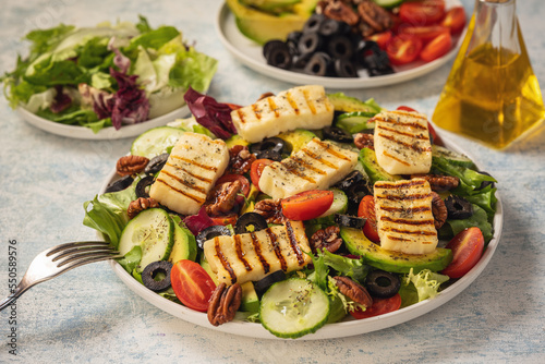 Greek style cuisine - salad with grilled halloumi cheese, avocado, pecan nuts and tomatoes.