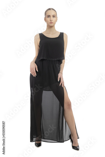 Beautiful slender model in a black dress. Long slim legs