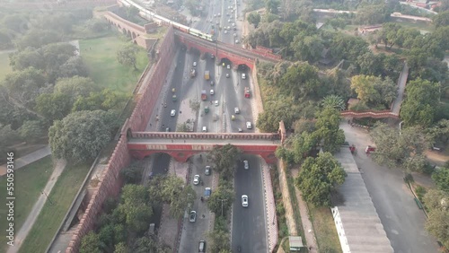 Aerial Drone shot of a Indian railways train crossing a bridge over a busy road at Red Fort in New Delhi India  photo