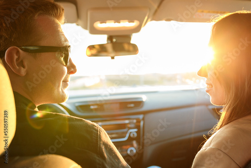 Close-up of happy faces of a man and a woman in a new car at sunset © makedonski2015