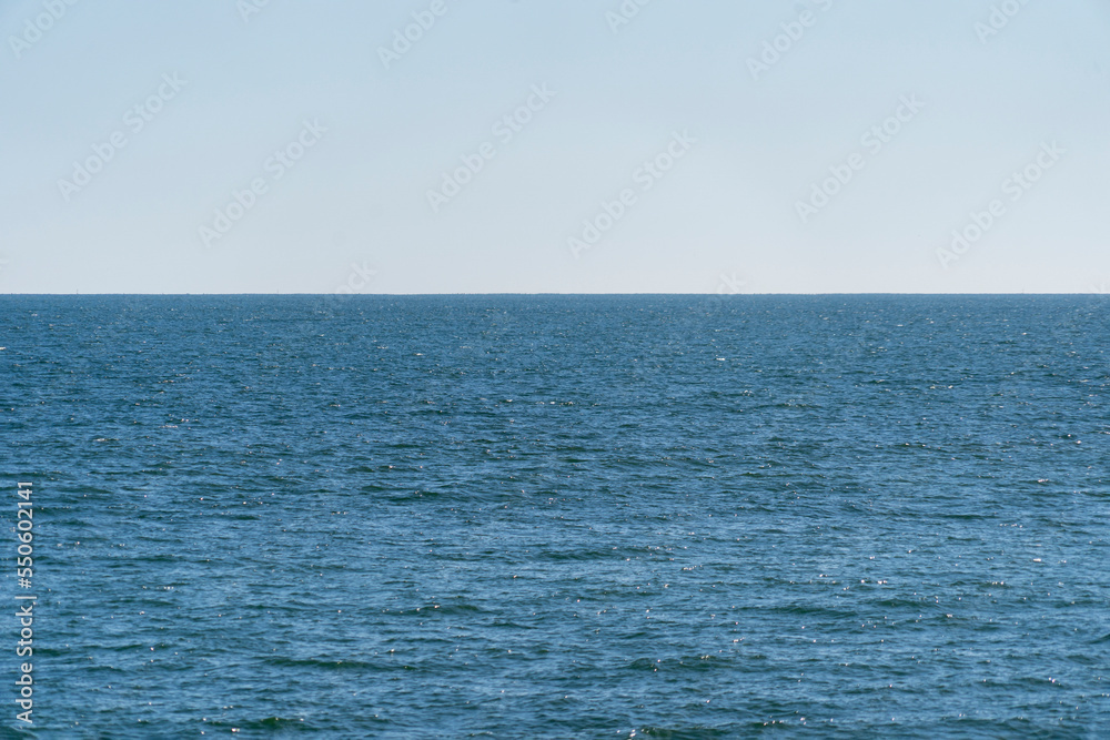 Obraz premium Blue ocean waves and sea water surface horizon with blue sky. Relaxing seascape backgound