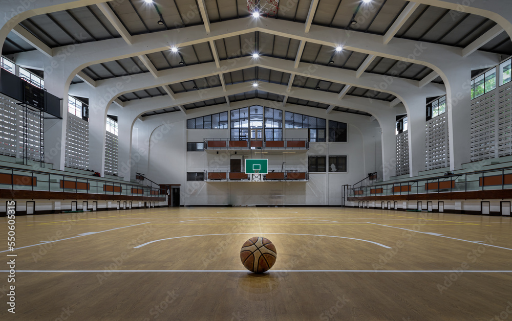 Basketball ball placed on court floor in the basketball gym. View from Empty basketball gym, Space for text, Selective focus.