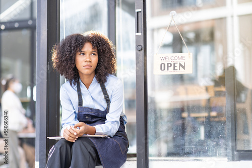 Obraz na plátně Portrait of Young african american small business owner woman wearing apron and looking away to you while waiting for her guest i in her small business shop