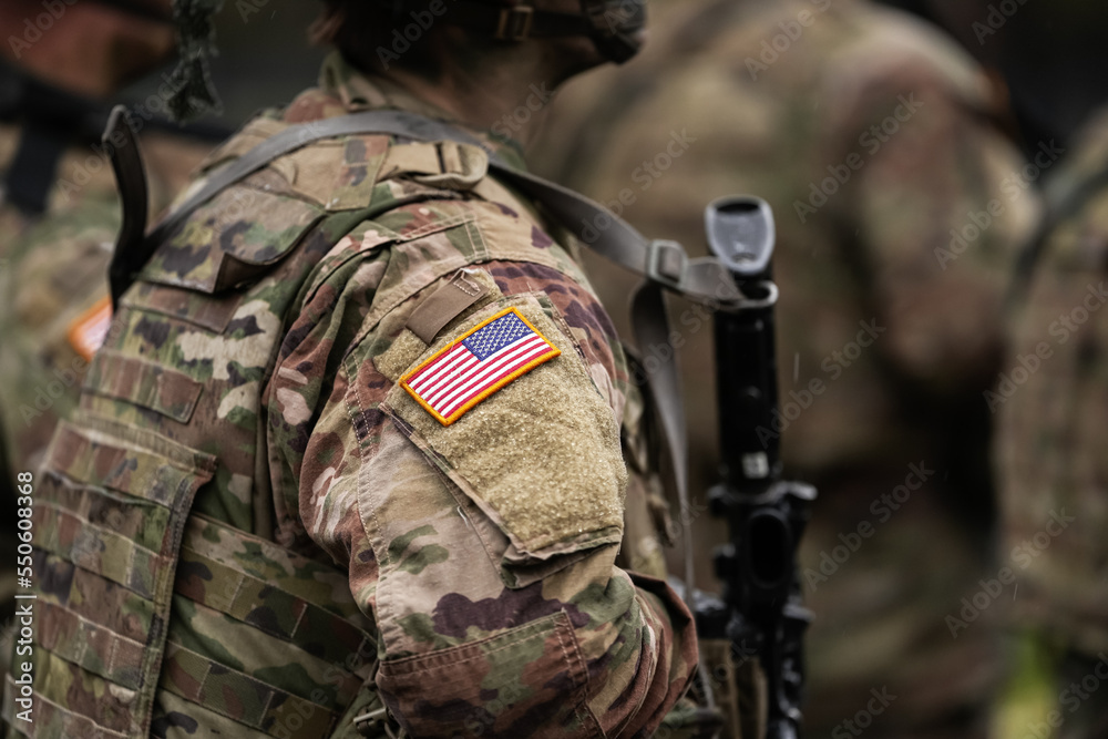 US Army soldiers uniform. Close up photo with the United States of America flag on a military soldier uniform with the gun next to it. Military industry detail concept photo.