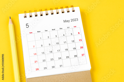 The May 2023 Monthly desk calendar for 2023 with pencil on yellow background.