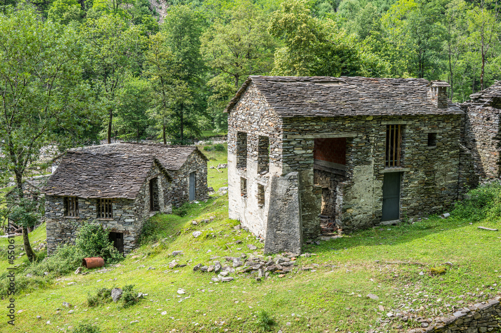 Ruined stone houses and mills in an abandoned mountain village in the Alps