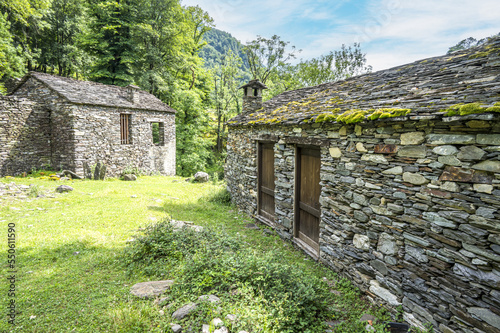Ruined stone houses and mills in an abandoned mountain village in the Alps