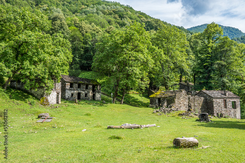 Ruined stone houses and mills in an abandoned mountain village in the Alps