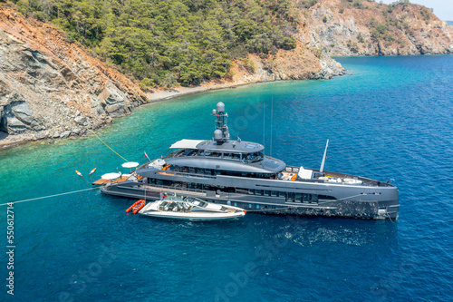 Aerial drone photo of modern yacht in Mediterranean port with deep blue sea.
