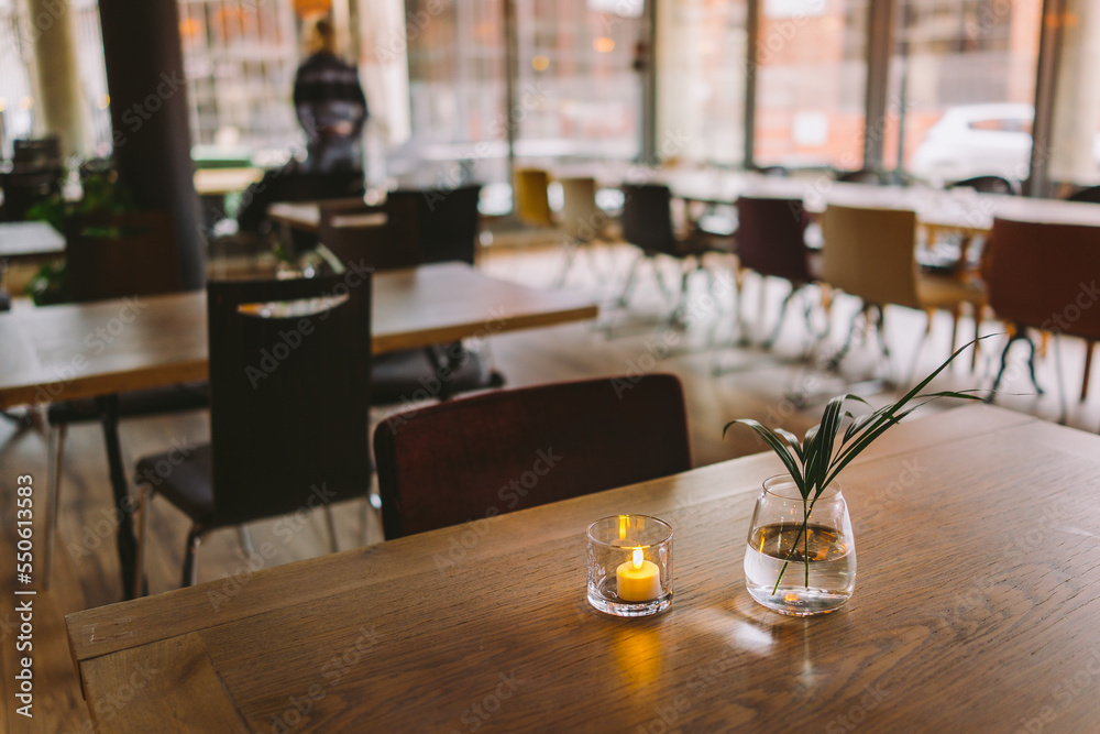 Table setup in a indoor restaurant with dish flowers and lights