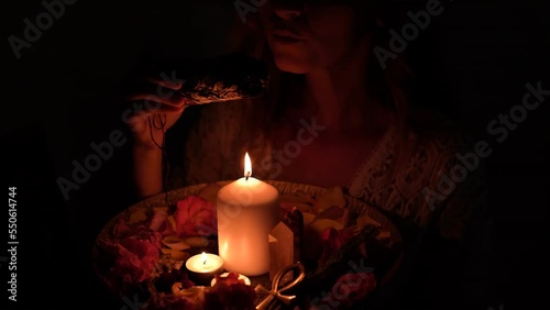 incense in a woman hand, incense smoke on a black background. photo