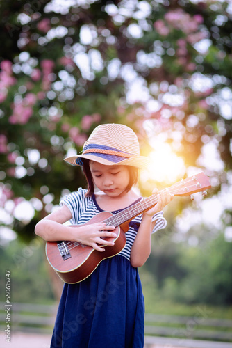 Beautiful asian girl playing ukulele, Outdoor portrait © chaunpis