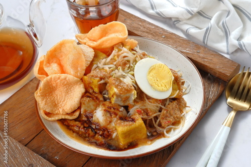 ketoprak-indonesian Traditional street food.dish of rice cake,rice noodles, bean curd, egg,boiled sprouts and served with peanut dressing. photo