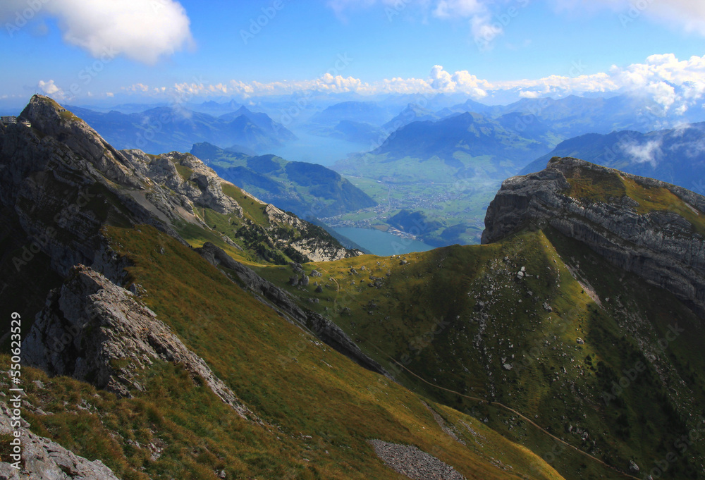 Landscape with a mountain in the foreground, mountains and river with lakes in the background, against the blue sky with clouds on Mount Pilatus, near Lucerne, Switzerland