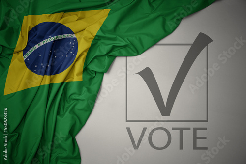 waving colorful national flag of brazil on a gray background with text vote. 3D illustration