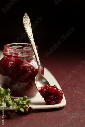 Bilde på lerret lingonberry sauce in a glass jar on a burgundy background