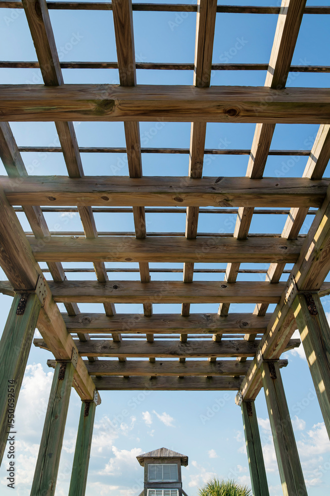 Destin, Florida- View of a wooden outdoor roof grid under the clear sky Destin, Florida- View of a wooden outdoor roof grid under the clear sky