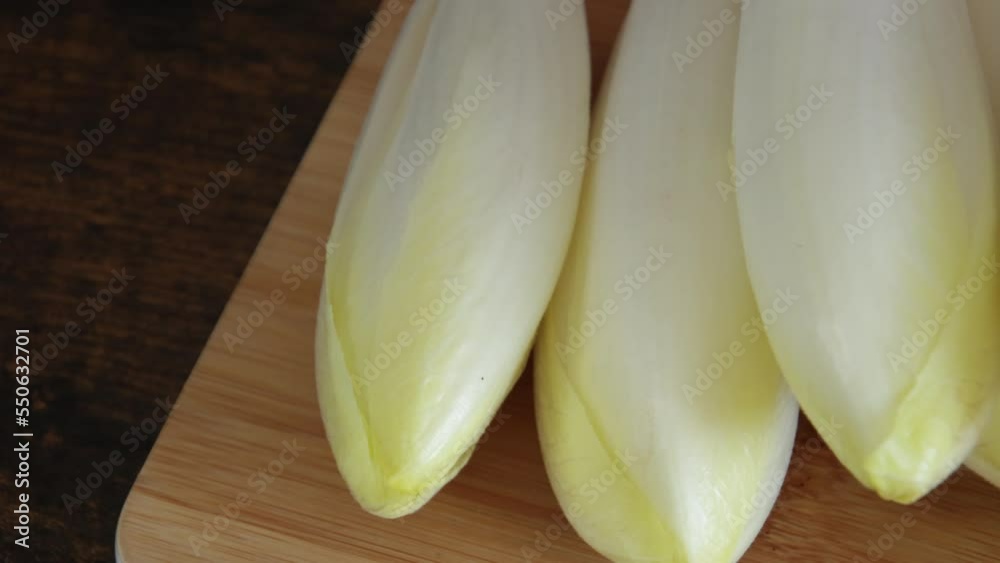 tas d'endives crus sur une planche à découper