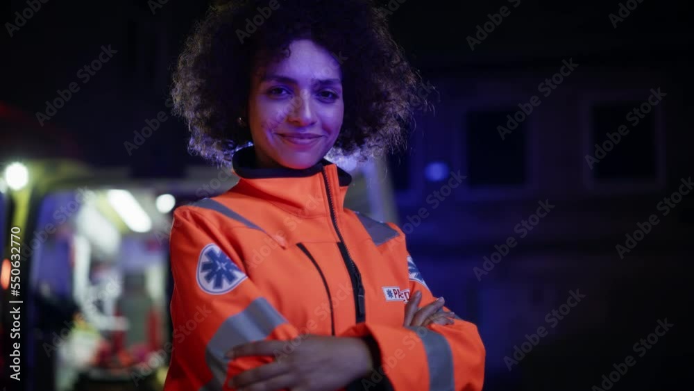 Arc Shot: Smiling Female Paramedic Looking at Camera and Posing with Crossed Hands. A Strong Multiethnic Professional Ready for Tackling Emergencies and Treating Patients on a Late Night Shift Arc Shot: Smiling Female Paramedic Looking at Camera and Posing with Crossed Hands. A Strong Multiethnic Professional Ready for Tackling Emergencies and Treating Patients on a Late Night Shift