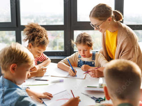 Teacher helping children with schoolwork