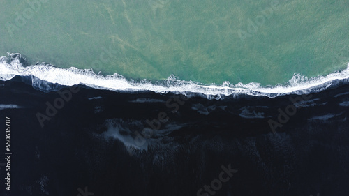 Aerial shot of black beach in Iceland and Atlantic ocean, shot from the drone
