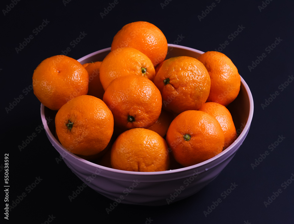 Ripe tangerines on a dark background. Close-up Ripe tangerines on a dark background. Close-up