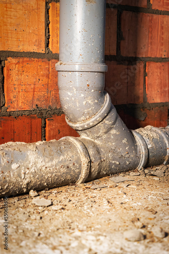 Sewer pipes in home basement. System of gray sanitary pipes when building a house. Sewer installation for sewage disposal.