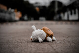 lonely teddy bear sleep on cement floor for created postcard  of international missing children, broken heart, lonely, sad, alone unwanted cute doll lost.