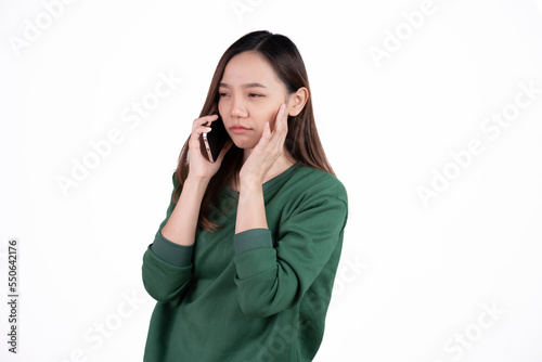 Portrait of a smiling casual asian woman holding smartphone over white background.