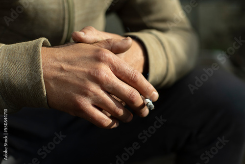 Cigarette in hand. Guy smokes. Man holds cigarette. Smoking is harmful to health.