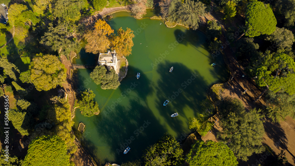 Obraz premium Aerial view of the small lake in Villa Borghese park. This pond is located in Rome, Italy. There are small row boats with people.